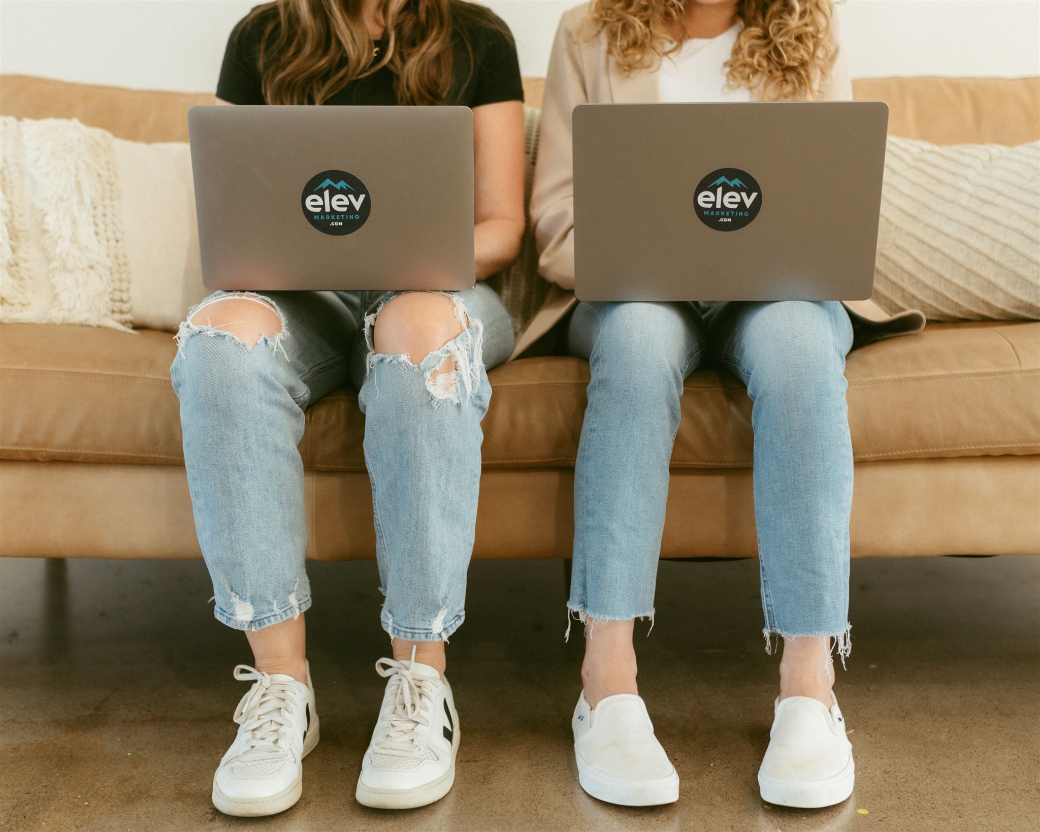 Amanda Joyce and Devon Hayes holding laptops for SEO Services in Elevation Marketing