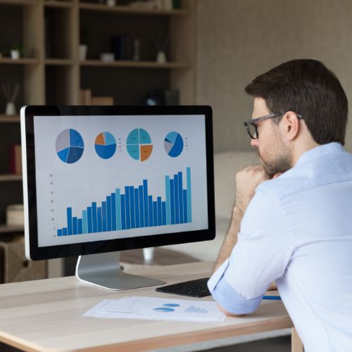 Marketing professional analyzing business growth charts to achieve consistent results year-round by Elevation Marketing