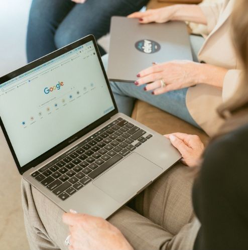 Marketing professionals reviewing Google search results on a laptop to address low visibility on Google with Elevation Marketing