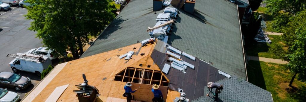 Roofing contractors on a roof are in the process of roof replacement