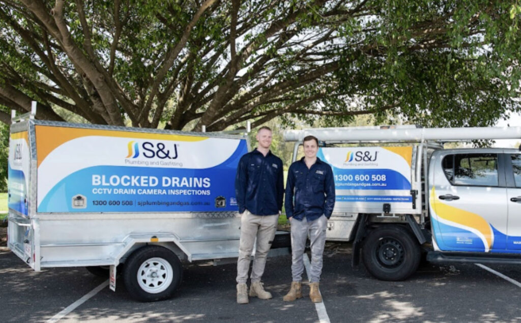 Plumbing team standing in front of branded service vehicles for SEO strategy case study by Elevation Marketing in Brisbane