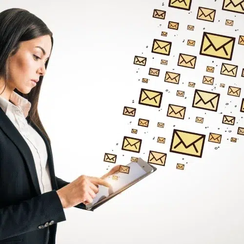 Business professional using a tablet as email icons stream outward, illustrating automated housekeeping email marketing funnel by Elevation Marketing™