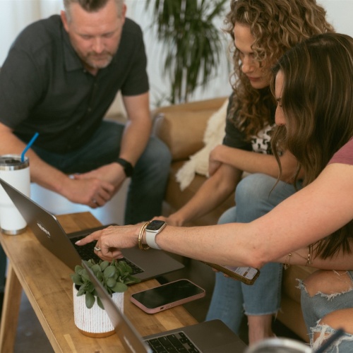 Marketing team collaborating on a laptop to fact-check AI output and reduce AI hallucinations in marketing by Elevation Marketing™
