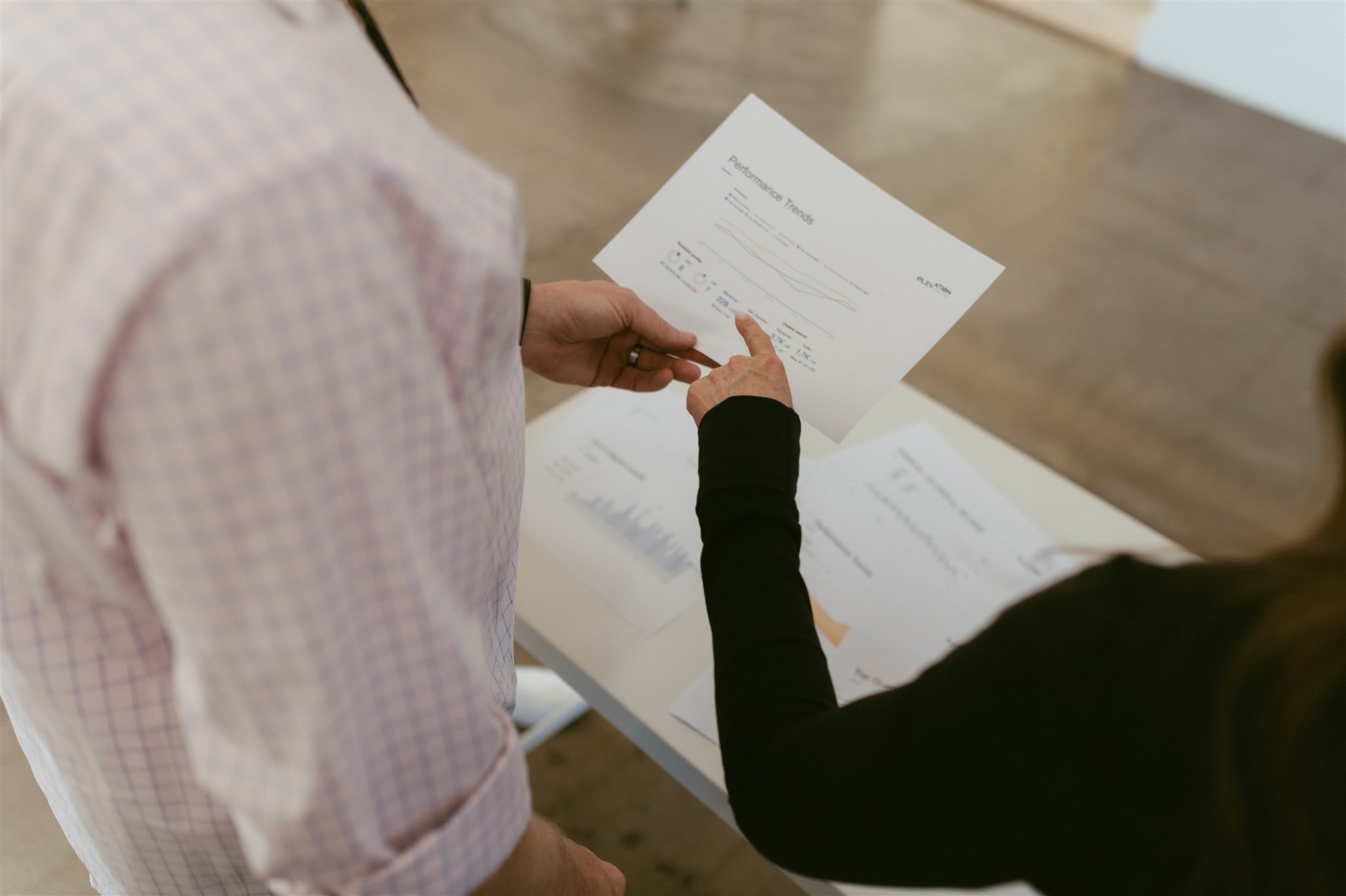 A team member pointing to a Performance Trends report to analyze return on investment and how much does contractor SEO cost contractor SEO in Denver by Elevation Marketing